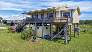 A two-story house with a covered porch and a small deck. - Awesome & Affordable 3 Bdrm, 2 Ba with easy beach access, and Gulf & Bay Views.  (Gulf Shores)