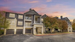 A row of two-story townhouses with balconies, garages, and a stone facade. - Landing | Incredible 1BD, Gym, Pool (Austin)
