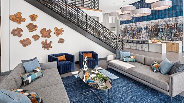 Ein modernes Wohnzimmer mit Treppe, Sofas und einem Couchtisch.