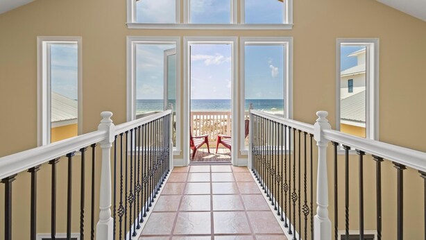 A spacious balcony with a view of the ocean, a tiled floor, and a railing. - Large Pet Friendly Gulf Front House with Pool and Elevator! (Gulf Shores)