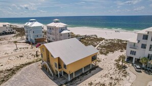 A coastal property with multiple buildings, a beach, and a pier. - Large Pet Friendly Gulf Front House with Pool and Elevator! (Gulf Shores)