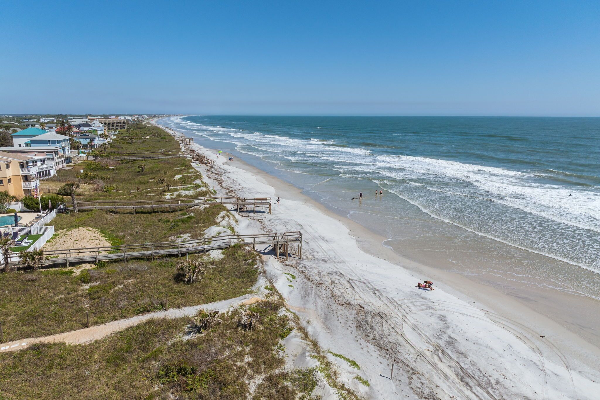 Une vue côtière comprenant une plage, l’océan et des immeubles résidentiels.