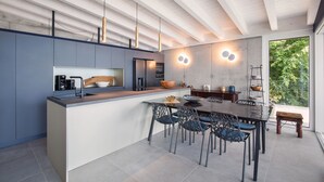 A modern kitchen with a central island, built-in appliances, and pendant lighting.