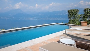 A swimming pool with a view of a distant city and mountains.
