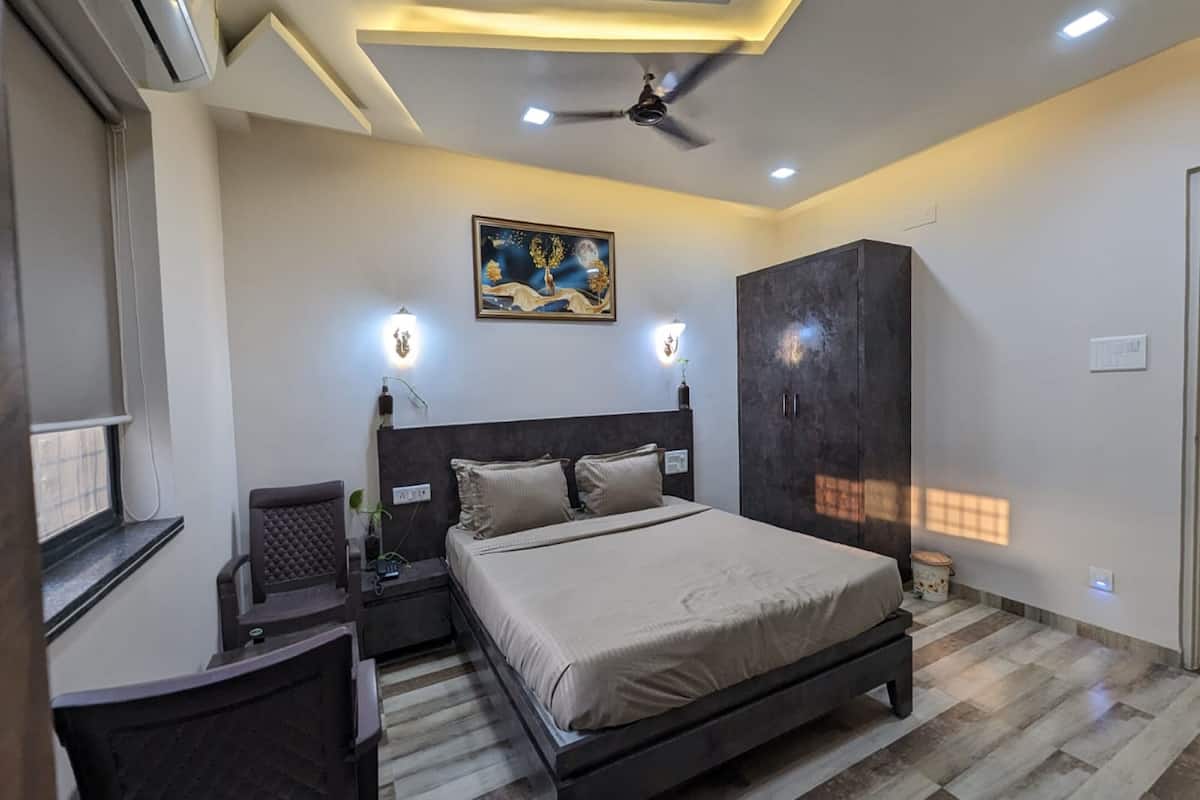 A bedroom with a bed, nightstands, a wardrobe, and a ceiling fan.
