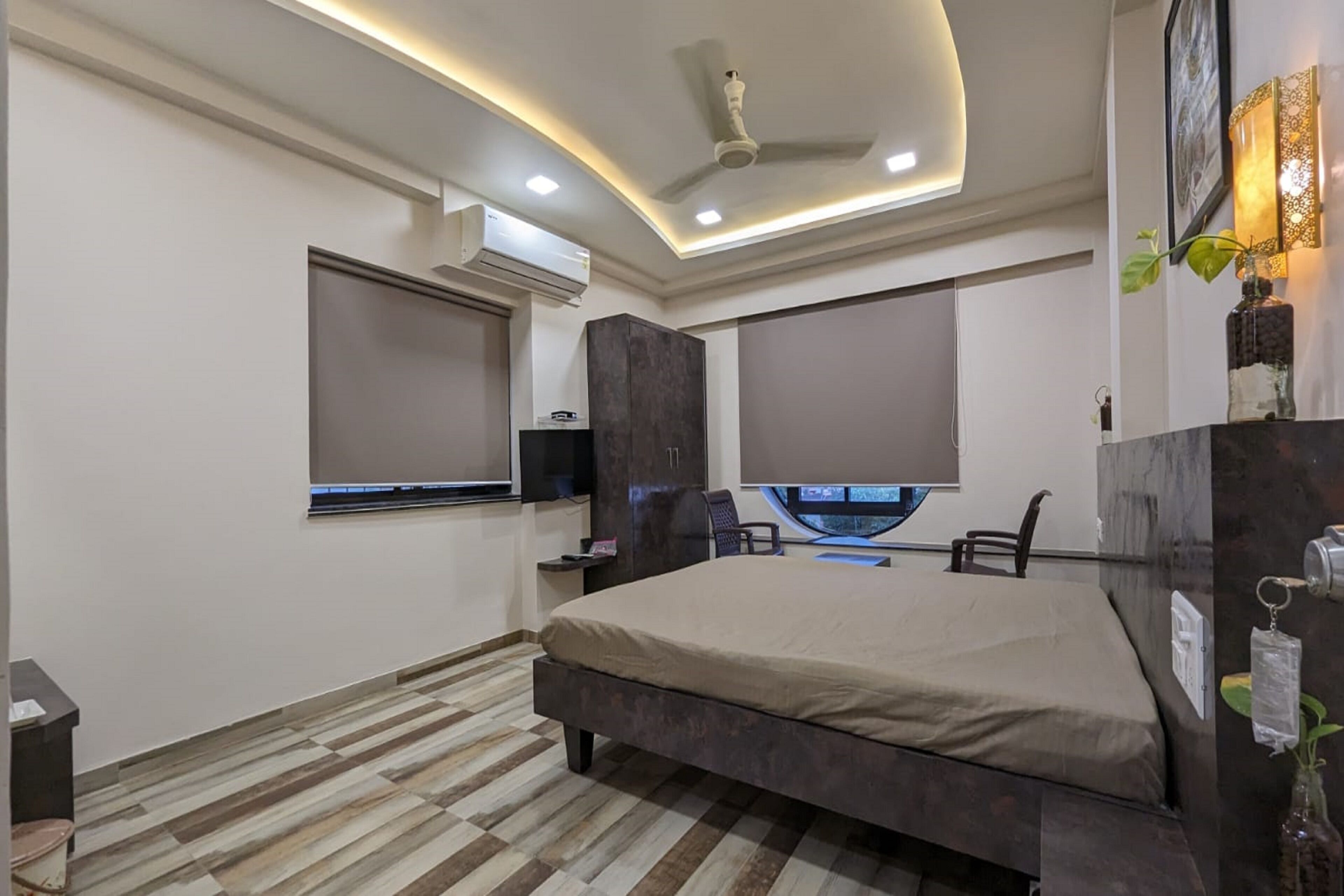 Un dormitorio moderno con una cama grande, televisor integrado y ventilador de techo.