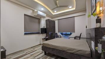 Un dormitorio moderno con una cama grande, televisor integrado y ventilador de techo.