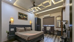 A modern bedroom with a large bed, bedside lamps, a desk, and a chair.