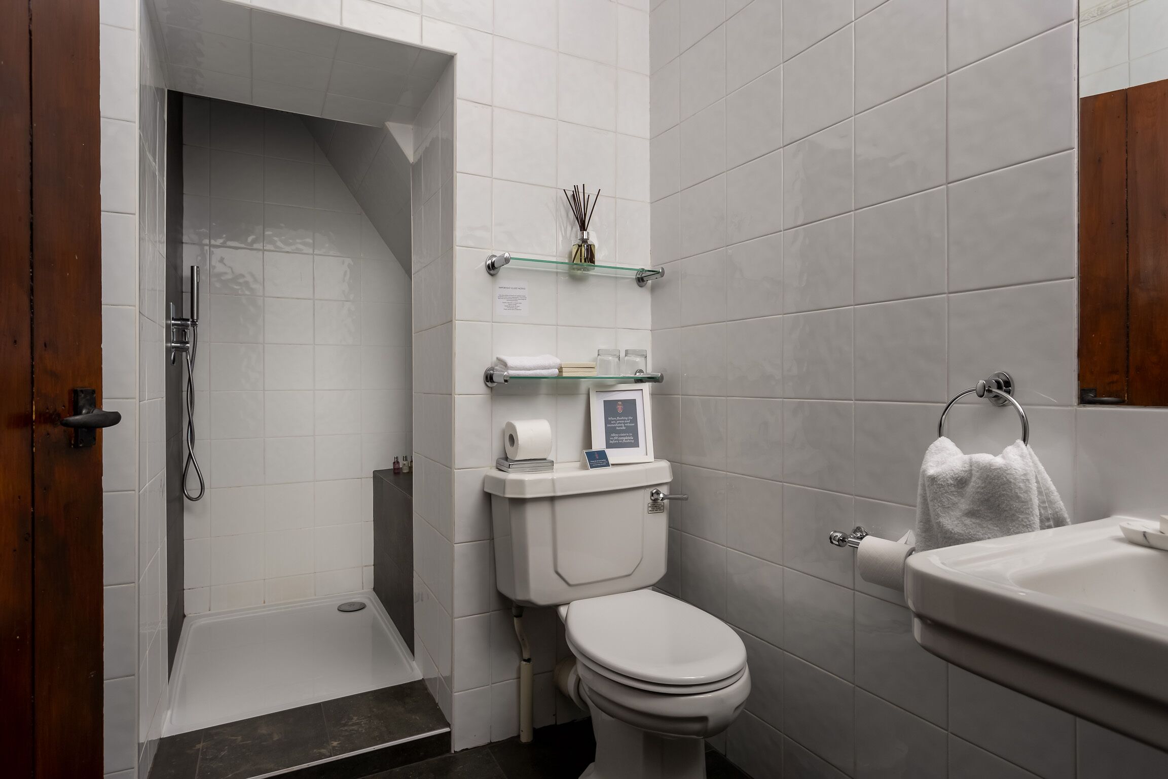 A modern bathroom with a shower, toilet, and sink.