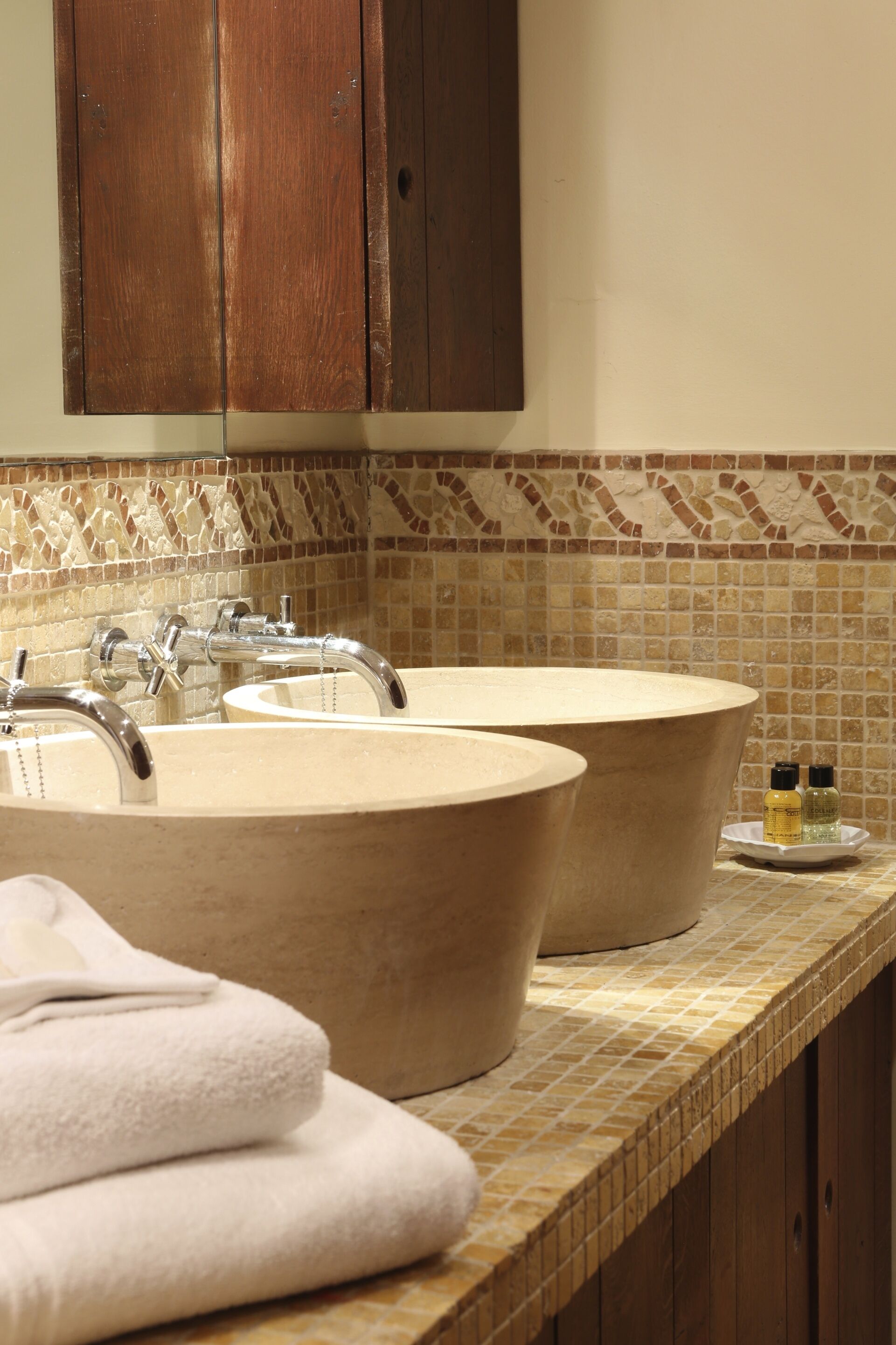 A bathroom with two sinks, a mirror, and a tiled backsplash.