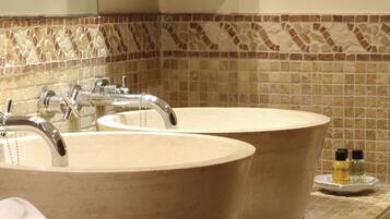 A bathroom with two sinks, a mirror, and a tiled backsplash.