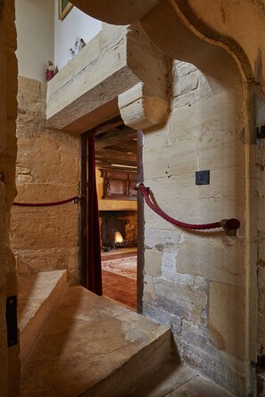 Una escalera de piedra que lleva a una habitación con chimenea.