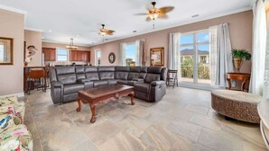 A spacious living room with a sectional sofa, a coffee table, and a dining area with chairs. - Big Balcony Breezes/Valhalla Laguna Key (Gulf Shores)