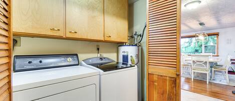 A laundry room with wooden cabinets and a washing machine.