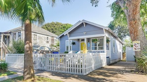 A single-story house with a white picket fence, a front porch, and a garage.