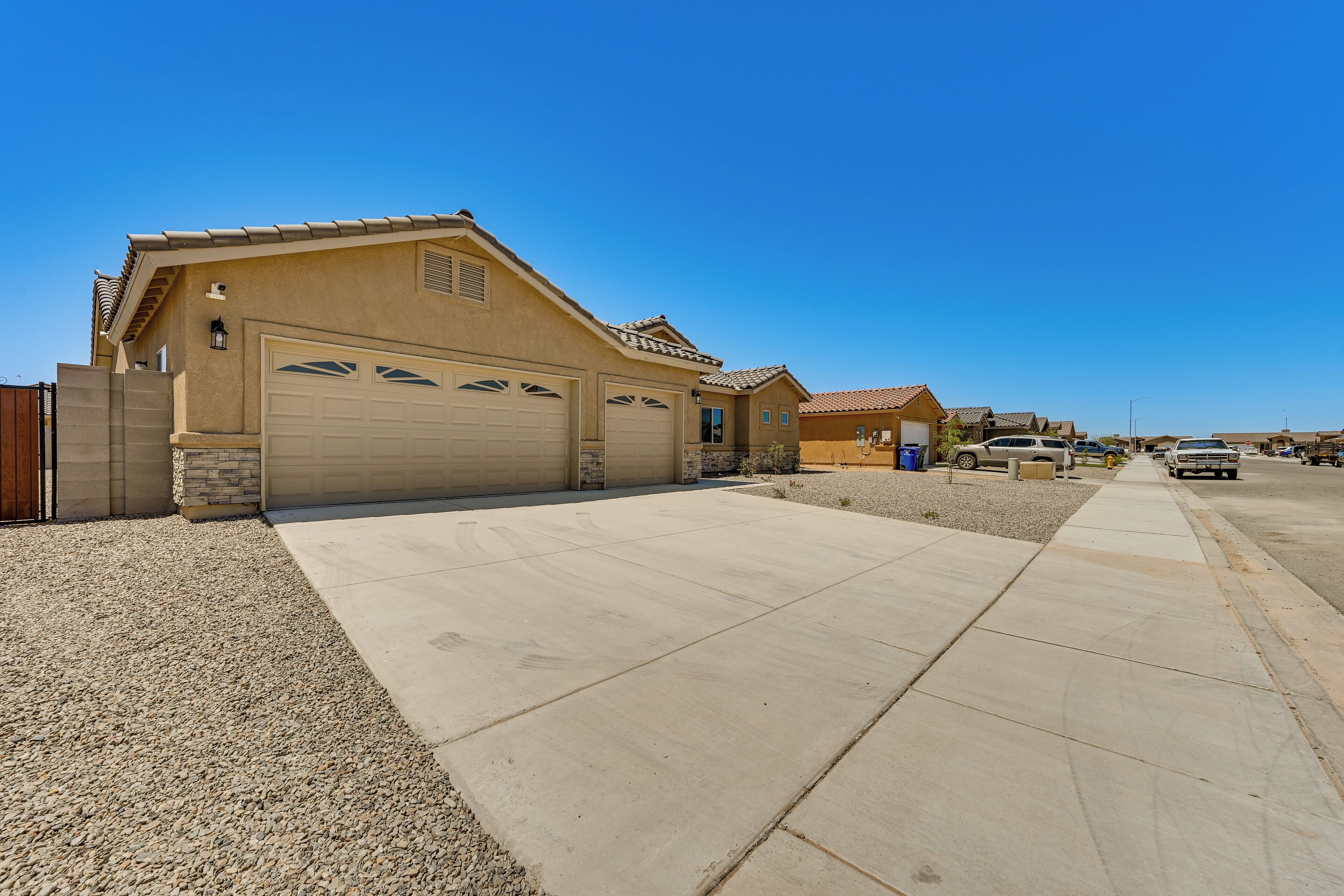 A residential area with houses, a driveway, and parked vehicles.