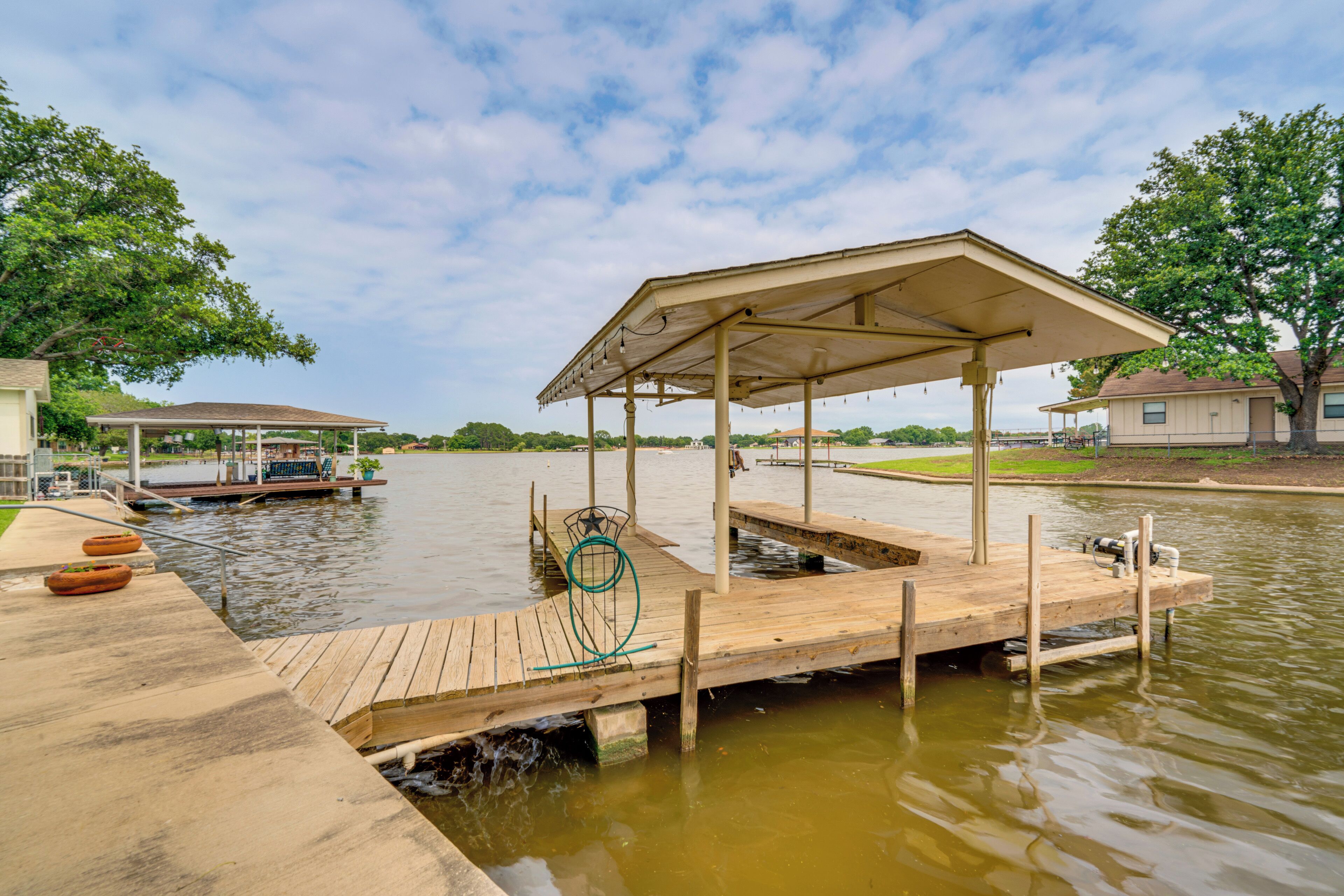 A wooden dock extending into a body of water with a covered pavilion.
