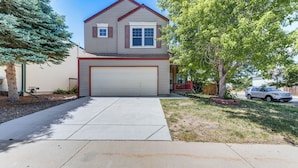 A two-story house with a garage, a driveway, and a lawn. - 15 Mi to Downtown Denver: Home w/ Yard + Patio (Aurora)