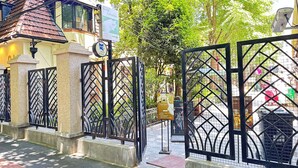 A gated entrance with a cafe and bar sign, a cat decoration, and a sign indicating a pet-friendly area. - Lian's Cozy Cottage next to ShaanXi S. Rd Subway STA nestled in Mid. Huaihai Rd. (Shanghai)
