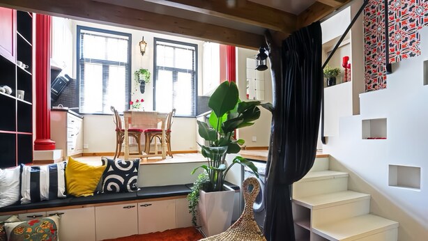 A modern interior with a staircase, a dining area, and a large plant. - Lian's Cozy Cottage next to ShaanXi S. Rd Subway STA nestled in Mid. Huaihai Rd. (Shanghai)
