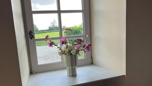 Ein Fenster mit einer Blumenkomposition auf einem Sims.