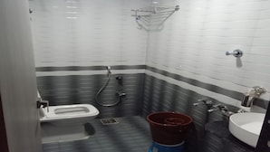 Une salle de bain avec des toilettes, une douche et un lavabo.