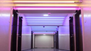 Un couloir doté d’un sol réfléchissant et de portes de part et d’autre.