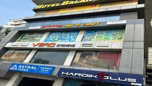 Un immeuble à plusieurs étages abritant divers commerces, notamment l’hôtel Balaji Inn, Snooz Art & Craft, Vero Kitchens, Astral Pipes, Hardik Plus et Hardik Plus Bath World.