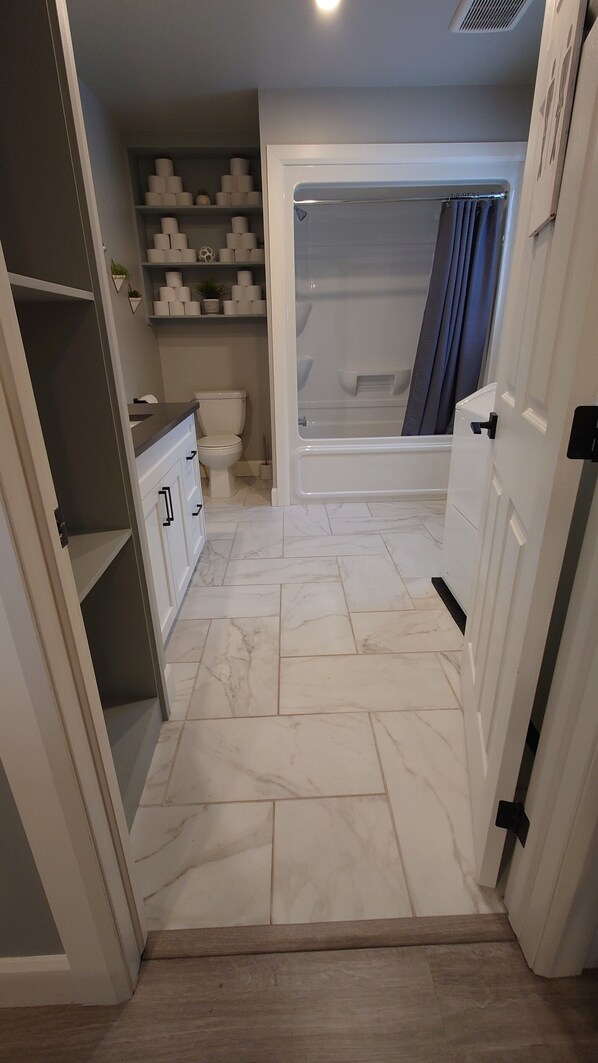 A bathroom with a toilet, a bathtub, and a shower area. - Waterfront Cottage | 3 bedroom | 1 bath | sleeps 6 people with Gourmet Kitchen (Arden)