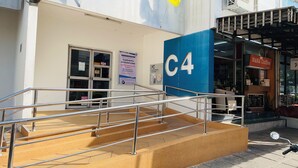 A building with a blue sign labeled 'C4' and a staircase leading to an entrance. - Impact Muangthong C1-C9 by Anna (Pak Kret)