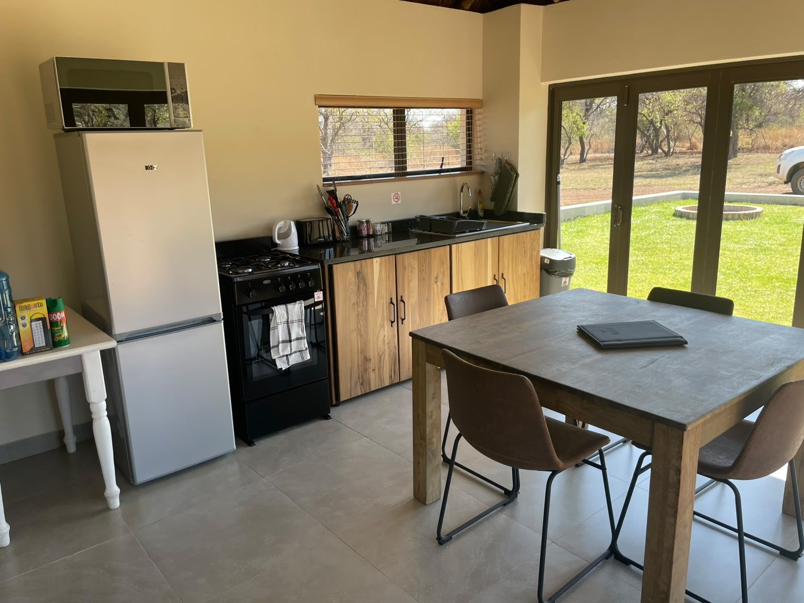 Une cuisine de taille réduite équipée d’une cuisinière, d’un évier et d’une table à manger avec des chaises.