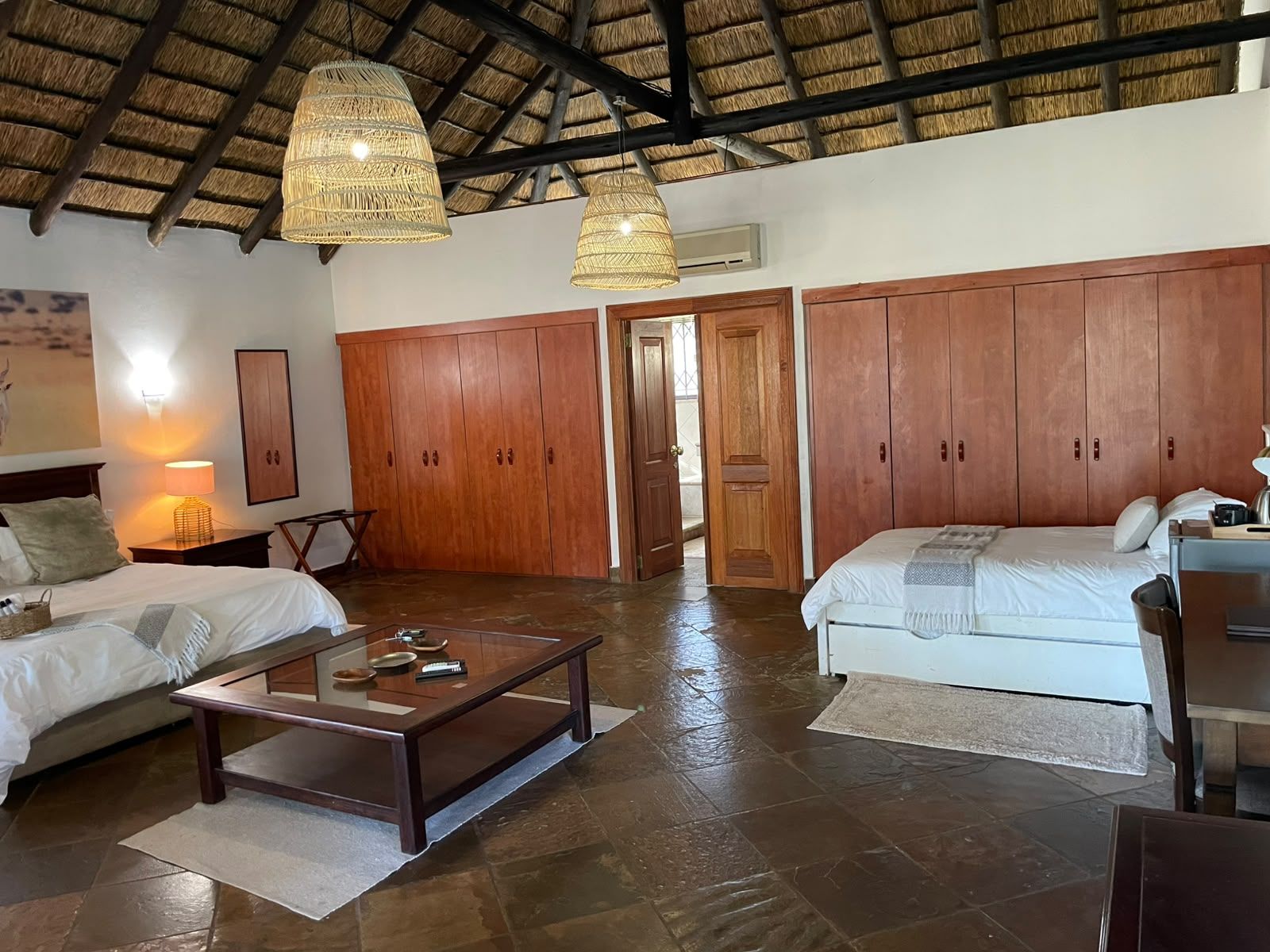 A room with a bed, a sofa, a coffee table, and a wardrobe.
