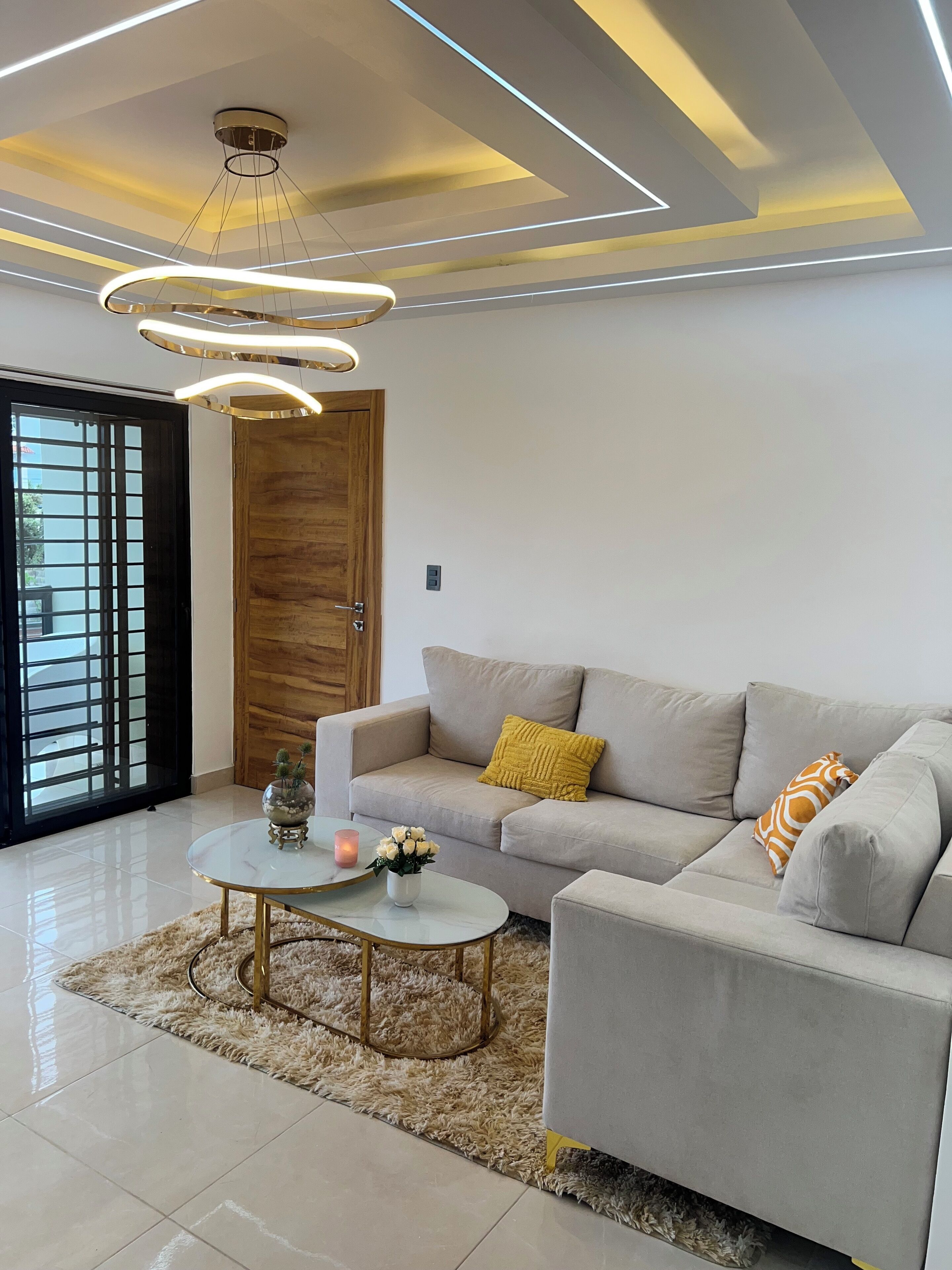 Een moderne woonkamer met een bank, salontafel en decoratieve accessoires.
