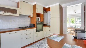 A kitchen with white cabinets, a microwave, an oven, and a gas stove.