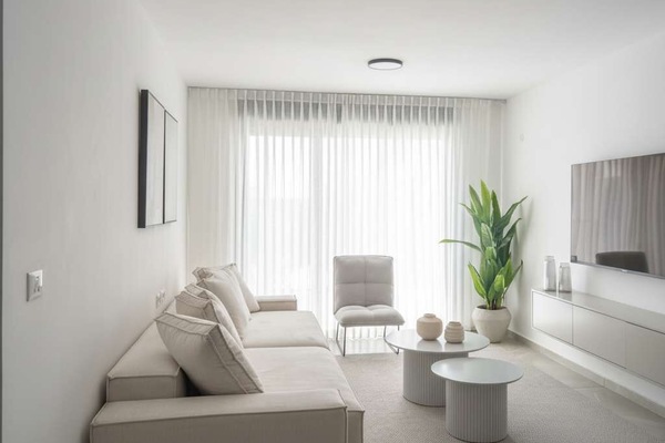 Bright minimalist lounge invites slow mornings, soft light filtering through curtains, moments of calm comfort.