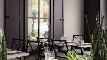 A dining area with tables, chairs, and a hanging lantern.