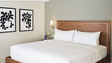 A neatly made bed with white linens in a hotel room.