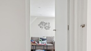 Käytävän lattia on tehty puusta, ja se johtaa olohuoneeseen. Sisäänkäynnin edessä on tervetulomatto.