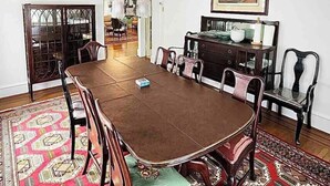 A dining room with a large table, chairs, a chandelier, and a painting on the wall. - American Adventure AC family beach home (Atlantic City)