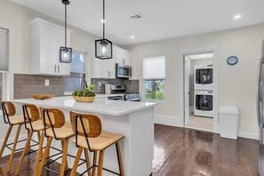 A modern kitchen with a large island, bar stools, and built-in appliances.