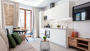 A modern kitchen with white cabinets, a microwave, and a TV mounted above the counter. - Myflats Luxury Cathedral (Alicante)