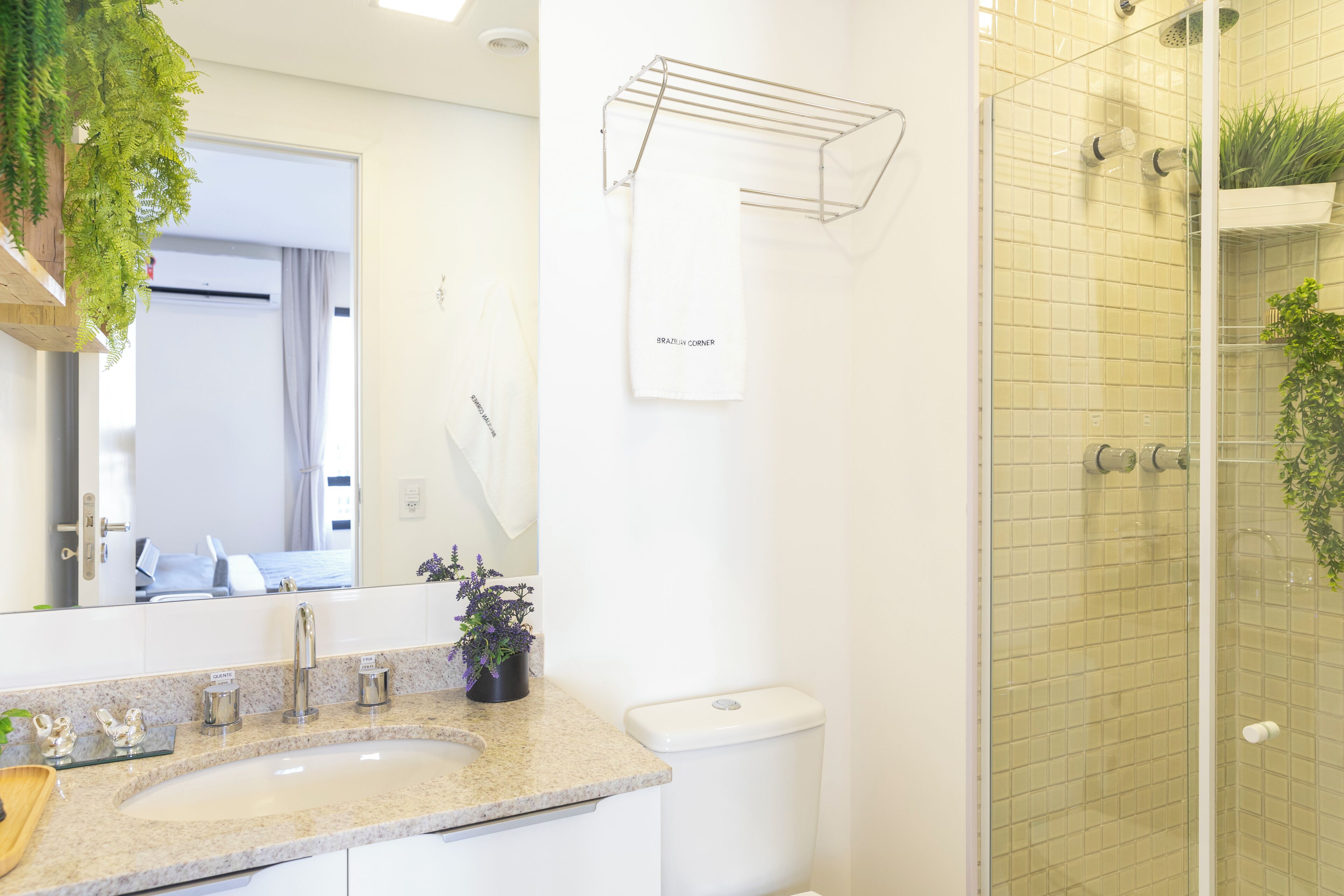 Un baño con lavabo, espejo, inodoro y zona de ducha.