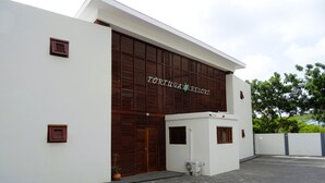 En modern byggnad med en skylt som visar texten "TORUGA RESORT".