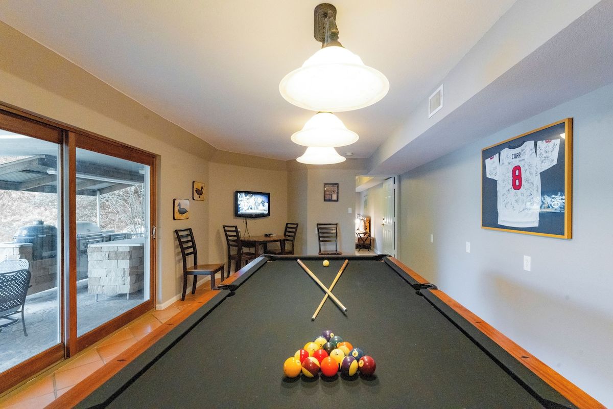 A pool table with a cue ball, billiard balls, and a framed picture on the wall.