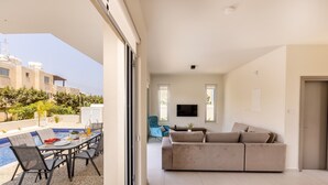 Un espacio moderno con piscina, sofá y televisor.