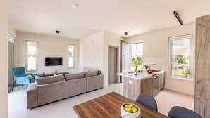 Un espacio habitable moderno con sofá, mesa de comedor y zona de cocina.