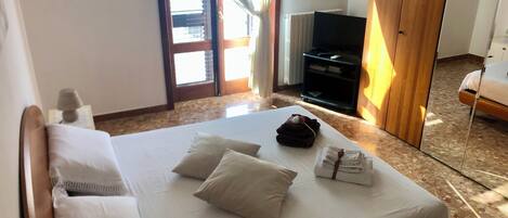 2 habitaciones, escritorio y tabla de planchar con plancha