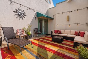 An outdoor seating area with a sofa, chairs, and a patterned rug. - Laurel Inn 606 is a spacious 2BR condo with private balcony close to downtown (Gatlinburg)