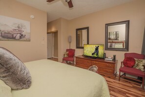 A hotel room with a bed, a television, a dresser, and two chairs. - Laurel Inn 606 is a spacious 2BR condo with private balcony close to downtown (Gatlinburg)