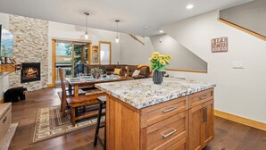 A spacious kitchen with a large island, wooden cabinets, and a stone accent wall. - 2 Queen Beds | Rec Center Access | 3-Min Drive to Village | Near Lake & Trails (Truckee)